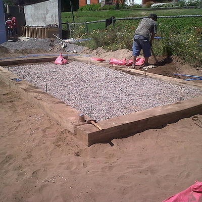 Jardín seco con durmientes y piedras decorativas